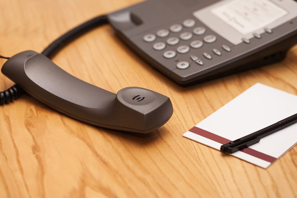 A remote control icon paired with a landline phone, illustrating the concept of remote control over landline devices